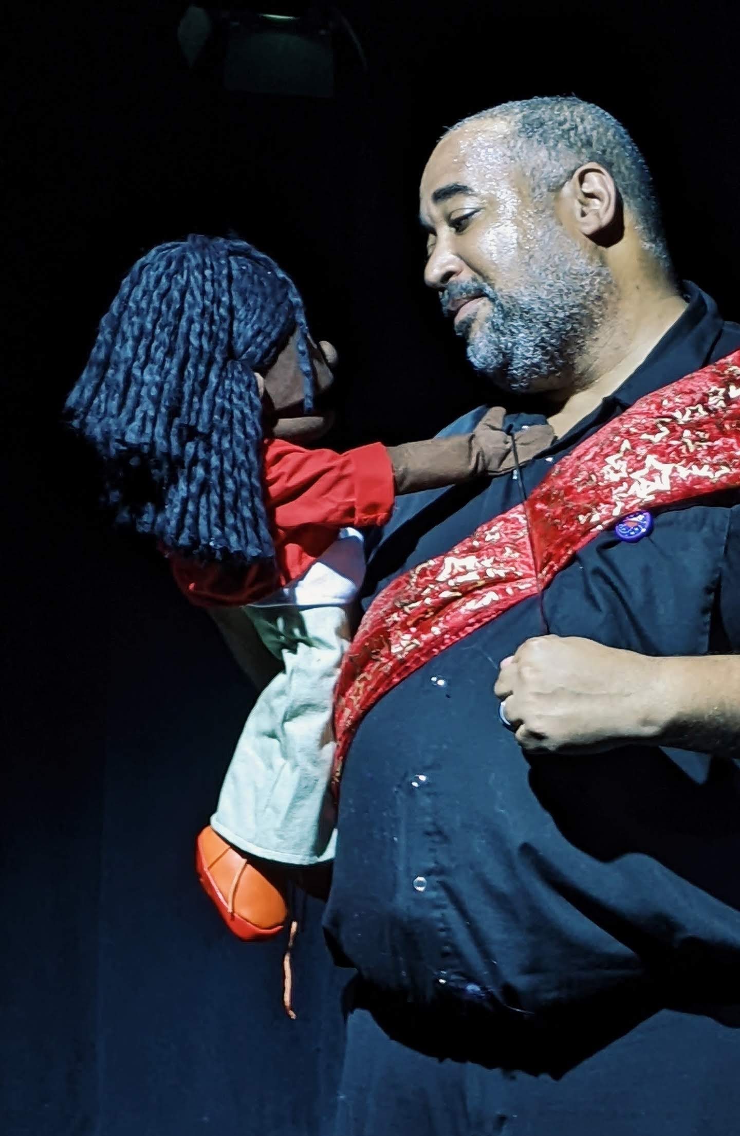 Photo from Ottawa Fringe Festival production of (Re)Tired Magical Black Man. Asase (Black female puppet) and dJerald (nonbinary Djinn) face each other, sharing platonic love. photo: Anna M